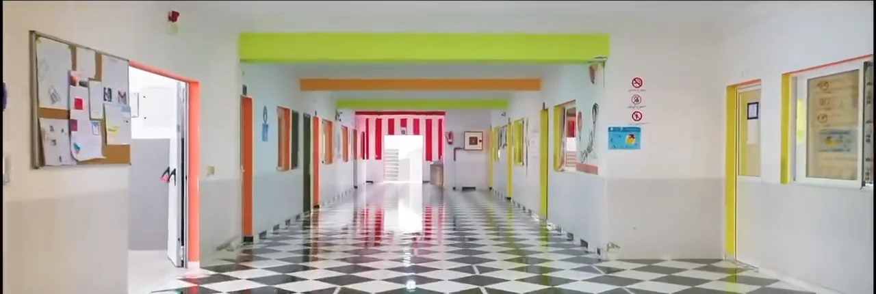 Couloir du cycle primaire de l'établissement, sol en damier et portes colorées