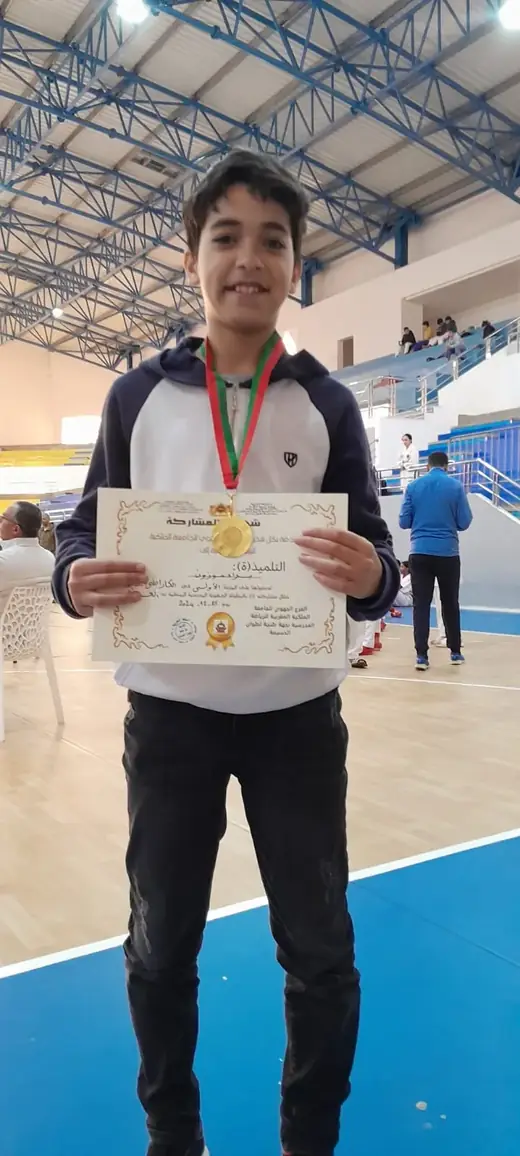 Élève d’Ajial Jebrane recevant un diplôme et une médaille