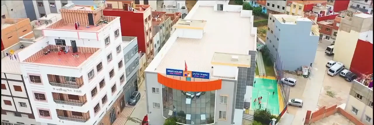 Le bâtiment de l'Établissement Ajial Jebrane vu du ciel, drapeau marocain en façade
